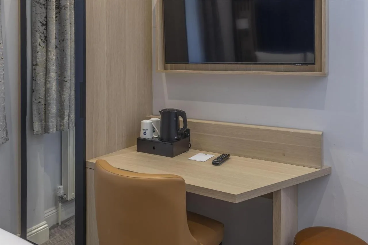 a desk with a coffee maker on it in a room at Best Western Victoria Palace in London