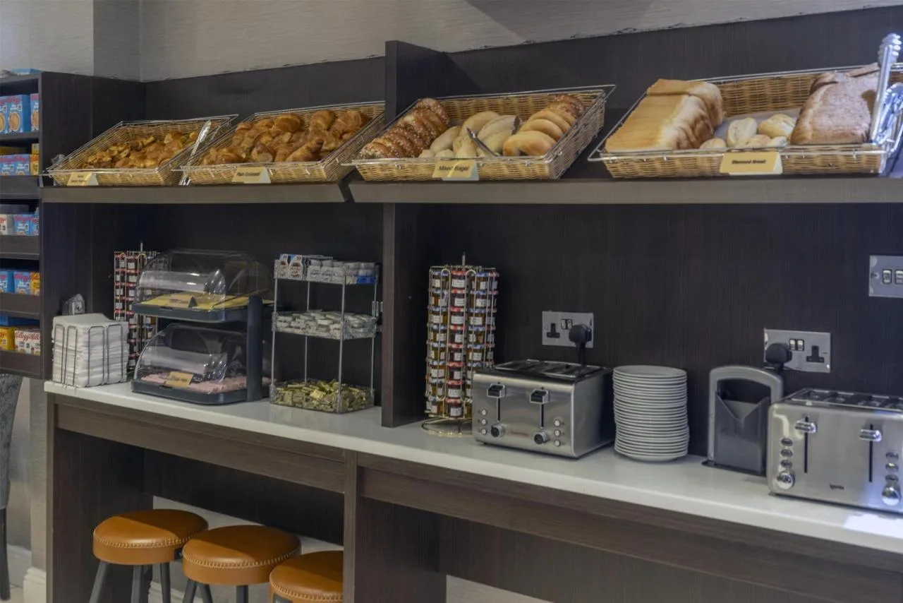 a bakery with bread and pastries on a shelf at Best Western Victoria Palace in London